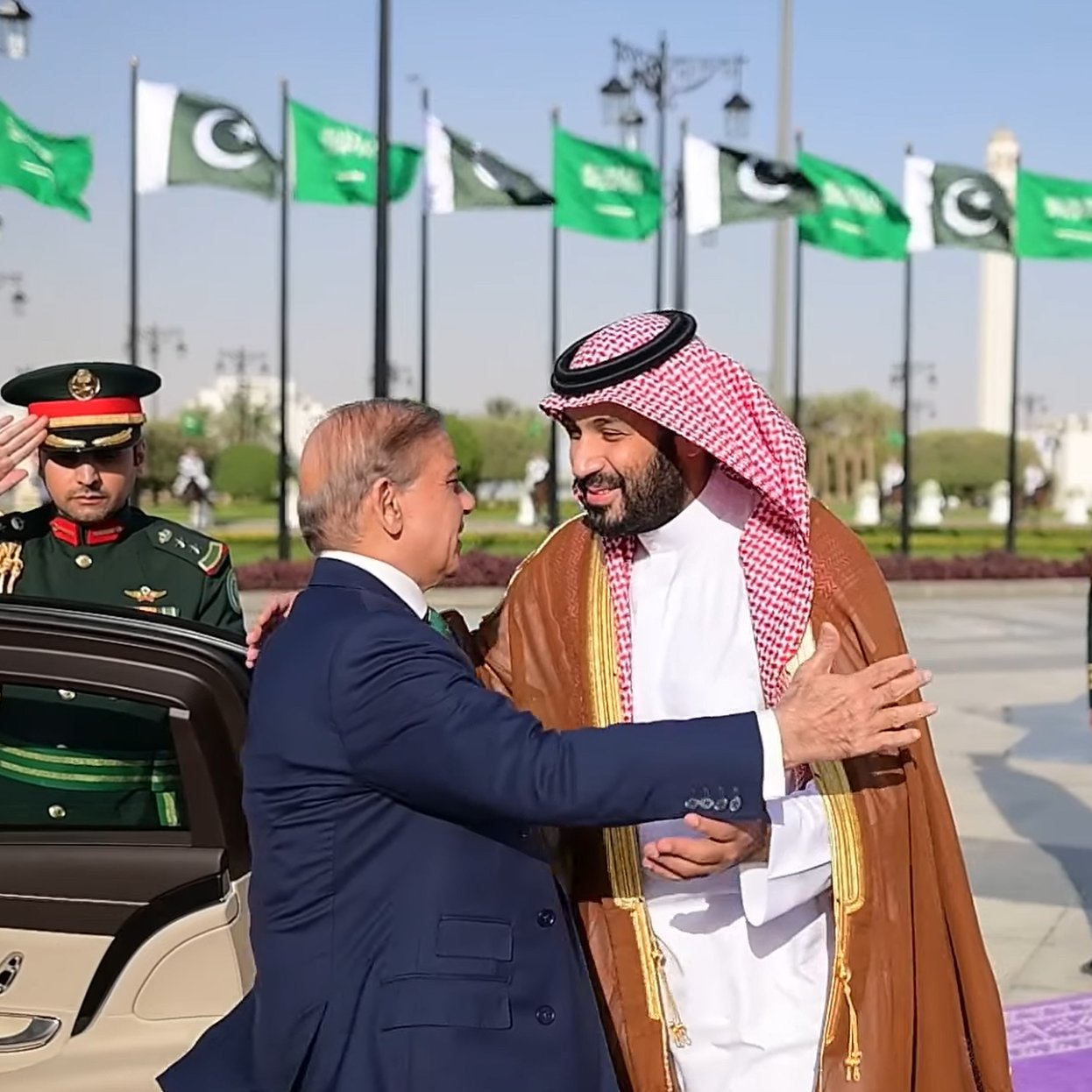 لقاء رسمي بين قائدين، مع أعلام وموظفين عسكريين في الخلفية.