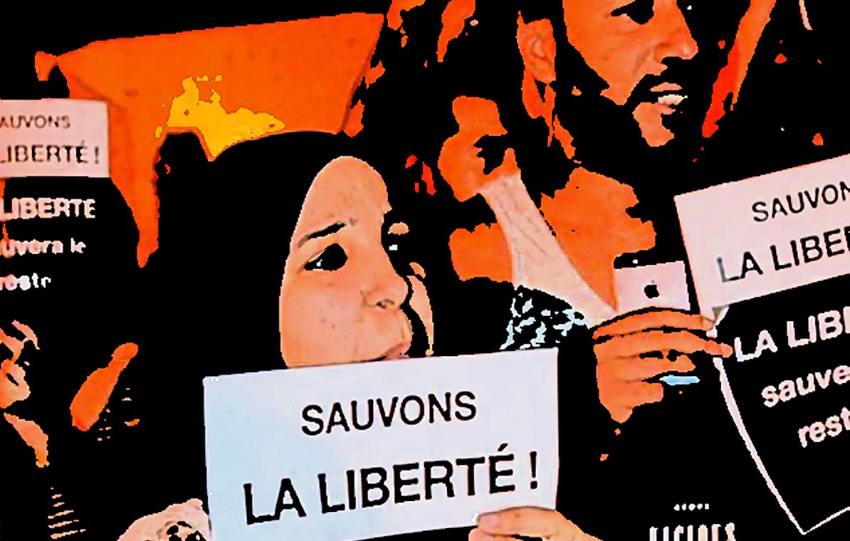 تظهر في الصورة مجموعة من الأشخاص المشاركين في احتجاج أو مظاهرة، حيث يحملون لافتات مكتوب عليها "لننقذ الحرية!" و"الحرية ستنقذ البقية...". يبدو من تعبيرات وجوههم أنهم متحمسون وملتزمون بالقضية التي يتظاهرون من أجلها. الخلفية تعكس أجواء حماسية ودعماً للقضية المطروحة.