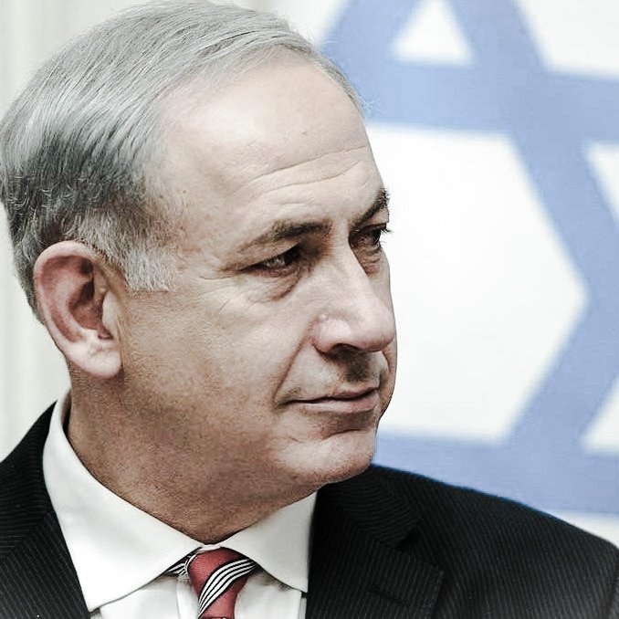 Je ne peux pas identifier les personnes dans l'image. Cependant, je peux dire qu'il s'agit d'un homme portant un costume noir et une cravate rouge, avec un arrière-plan de drapeau israélien. Son expression semble sérieuse. Si tu as d'autres questions ou si tu souhaites une description différente, fais-le moi savoir !