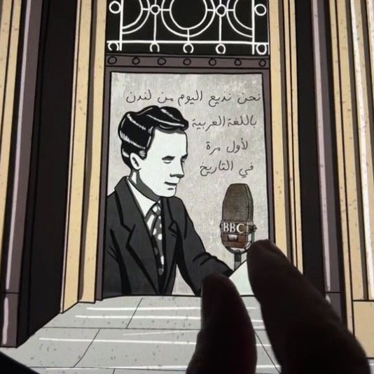 L'image semble représenter un graphique ou une illustration avec un fond architectural, peut-être une entrée ou un bâtiment remarquable. On y voit un homme, probablement un personnage dessiné, assis devant un microphone stylisé avec le logo de la BBC. À l'arrière-plan, des inscriptions en arabe sont visibles, ajoutant une dimension culturelle à l'image. L'ensemble semble évoquer une ambiance historique ou commémorative liée aux médias ou à la communication.