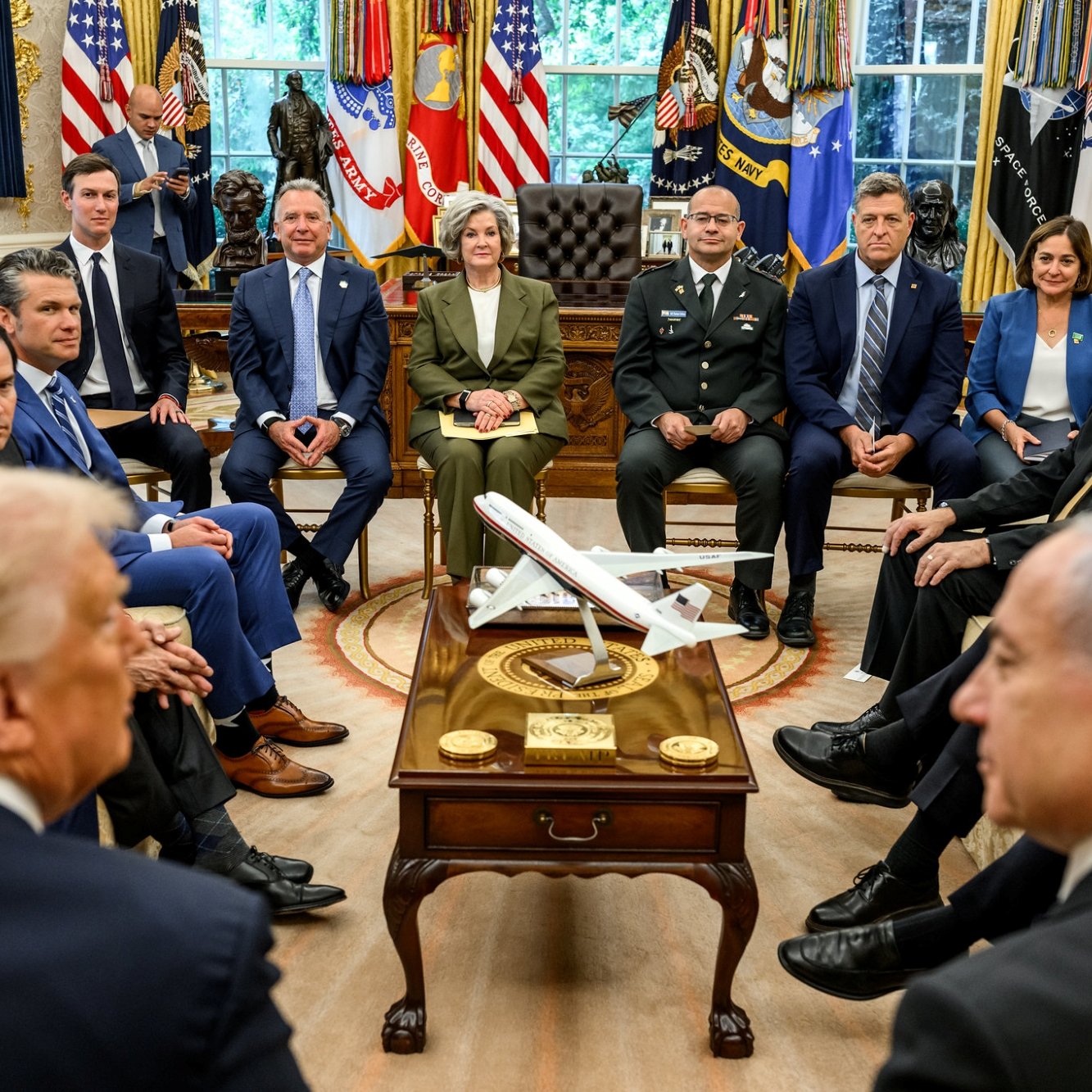 Des responsables politiques discutent autour d'une table dans un bureau officiel.