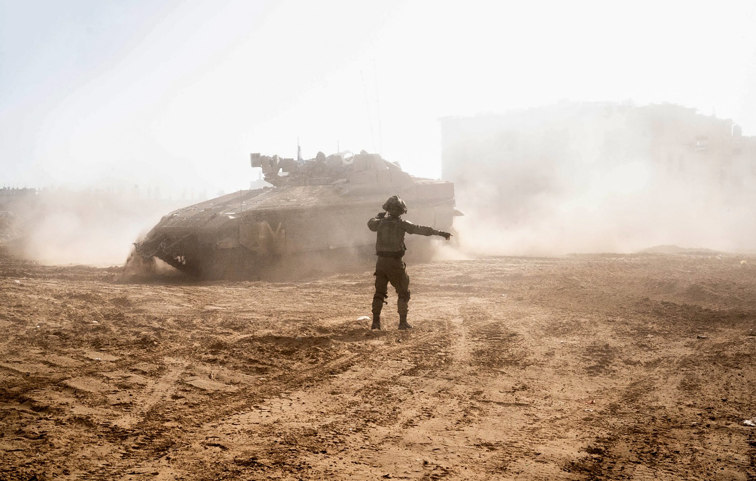 L'image montre un soldat illustré au milieu d'une scène de poussière et de chaos, semblant donner des ordres ou communiquer avec son équipe. En arrière-plan, un char d'assaut est partiellement visible, entouré de nuages de poussière soulevés par son mouvement. La lumière est vive, créant une ambiance de tension et d'intensité dans un environnement de conflit.