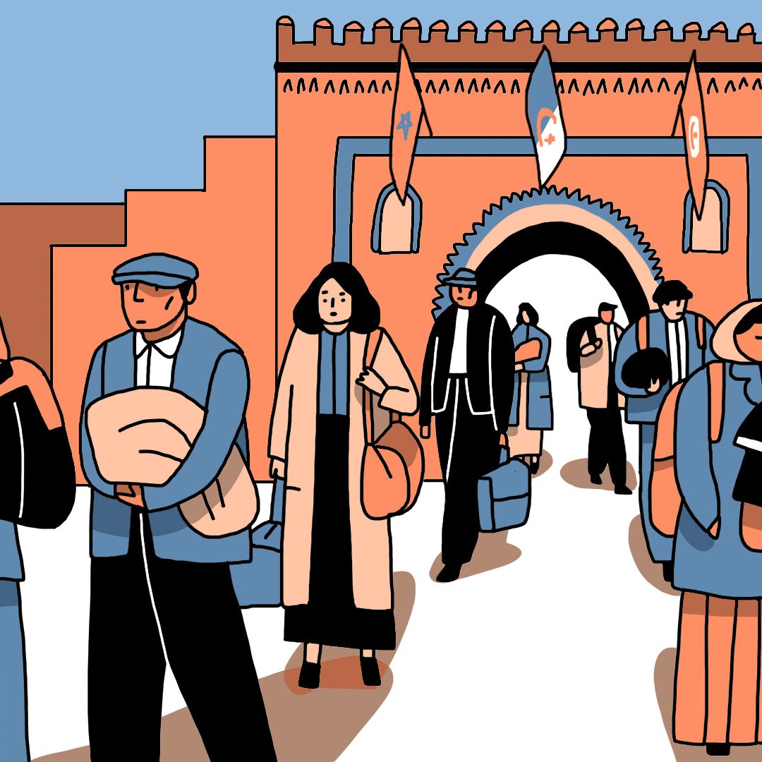 L'image montre un groupe de personnes marchant dans une rue animée, avec une architecture colorée en arrière-plan. Certaines personnes portent des vêtements traditionnels, d'autres des tenues modernes. On remarque également des drapeaux français et israéliens flottant. Le groupe semble traverser un passage avec des arches, suggérant un lieu historique ou culturel. Les expressions des personnes sont variées, allant de la détermination à la douceur, et certaines portent des enfants ou des bagages.