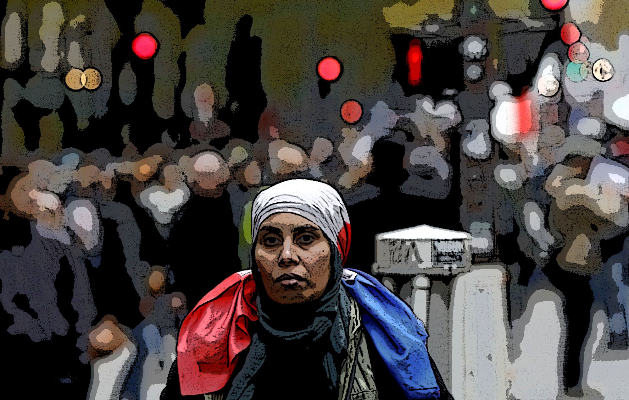 L'image représente une femme au premier plan portant un foulard et une écharpe aux couleurs bleu, blanc, rouge, qui symbolisent le drapeau français. En arrière-plan, on voit une foule floue, suggérant une atmosphère urbaine animée. Les lumières au loin ajoutent une touche de couleur à l'ambiance générale, offrant un contraste avec la concentration de la femme au centre de l'image.