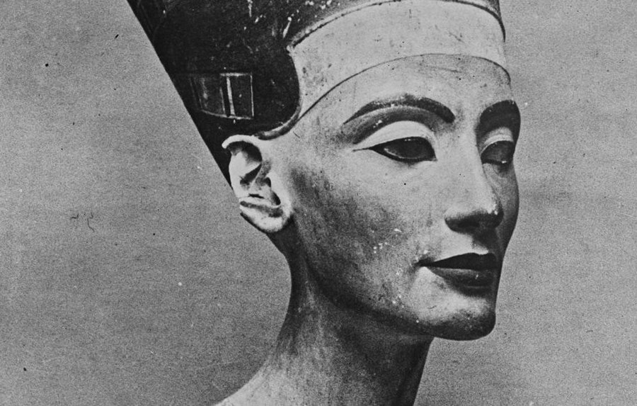 L'immagine rappresenta un busto di pietra di una figura femminile, noto per essere la regina Nefertiti, famosa per la sua bellezza e per il suo ruolo nella storia dell'antico Egitto. Il busto è caratterizzato da un copricapo distintivo e da dettagli elaborati sulla collana e sul viso. La scultura ha un aspetto realistico e raffinato, evidenziando l'arte egizia antica. Il colore della pietra è chiaro con alcune dorature, e l'espressione del volto è serena e dignitosa.