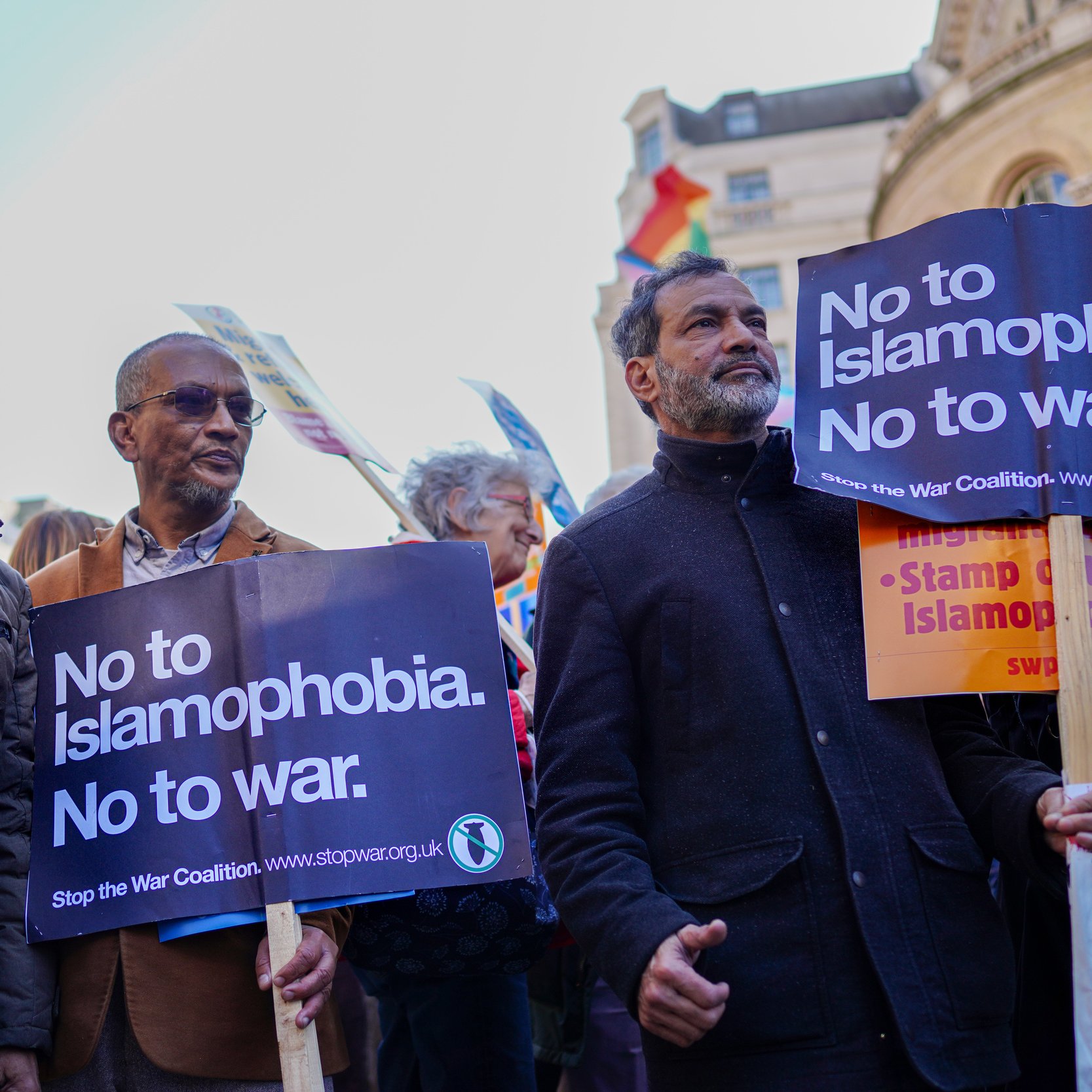 L'image montre un groupe de personnes participant à une manifestation. Elles tiennent des pancartes avec des messages clairs, notamment "No to Islamophobia. No to war." et "Stop the War Coalition". Les manifestants expriment leur opposition à l'islamophobie et à la guerre. On peut voir des personnes de divers âges et origines, toutes unies par leur cause. L'ambiance semble engagée et déterminée.