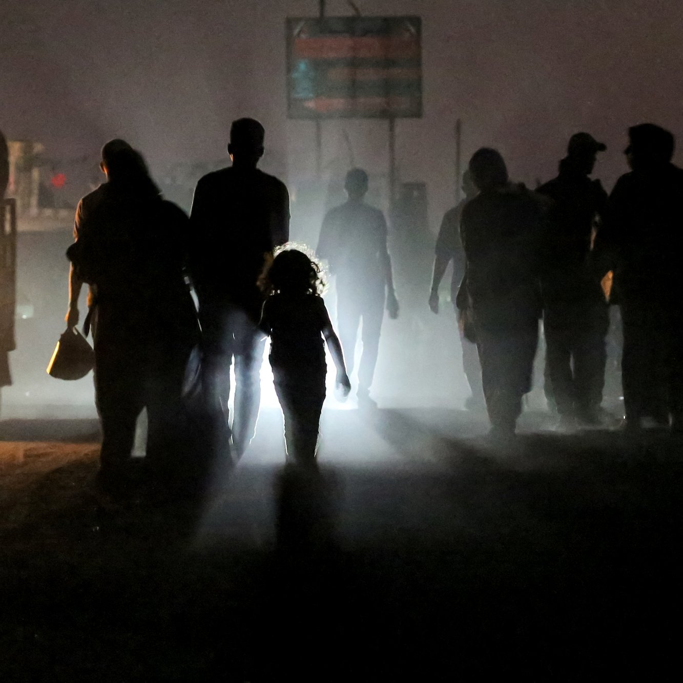 Silhouettes de personnes marchant dans une ambiance brumeuse, une enfant éclairée au centre.