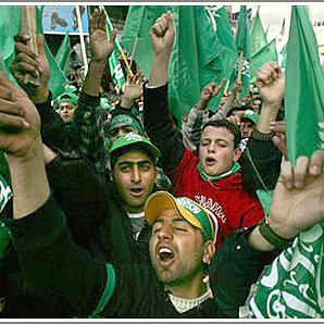 L'image montre une foule de personnes brandissant des drapeaux verts, manifestant de manière énergique. On peut voir des groupes de jeunes hommes exprimer leur enthousiasme, certains chantant ou criant. L'atmosphère semble festive, avec des expressions de joie et de solidarité parmi les participants. Les vêtements et accessoires des manifestants reflètent une allure colorée, souvent associée à des symboles politiques ou culturels.