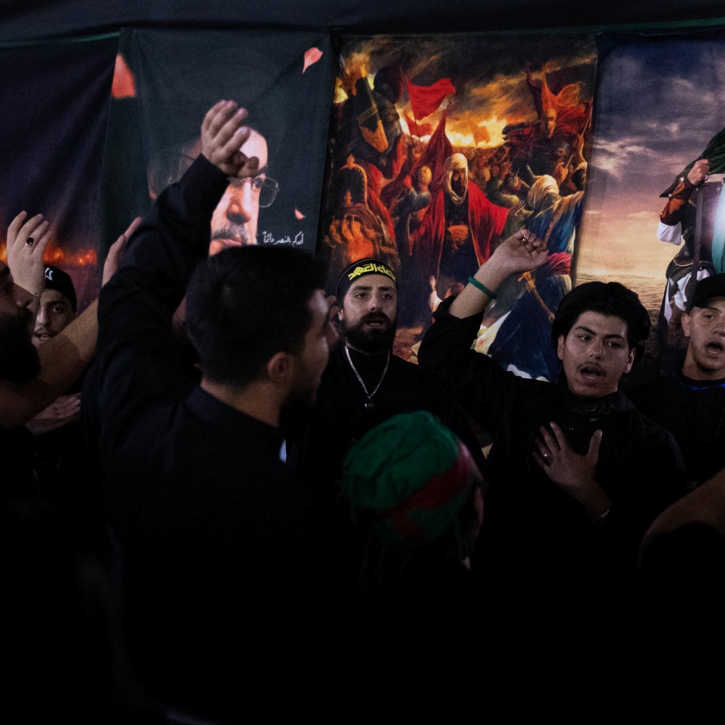 Des hommes en vêtements noirs chantent et montrent des signes de dévotion.