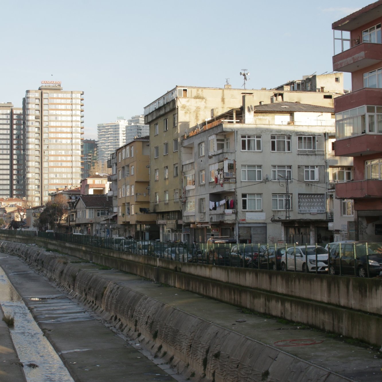Vue d'une rue avec des immeubles modernes et des bâtiments anciens, le tout au bord d'un canal.
