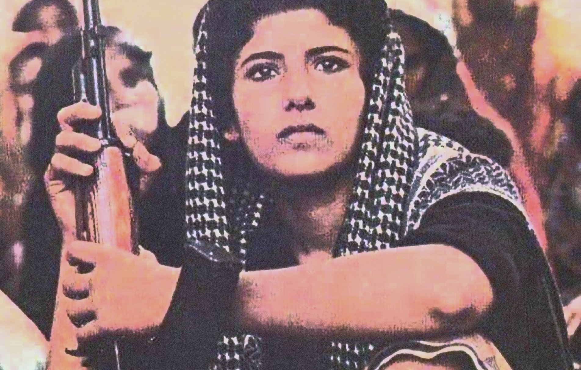 La imagen muestra a una persona joven con una mirada seria, sentada y sosteniendo un rifle. Lleva un atuendo que incluye un pañuelo en la cabeza y una vestimenta que parece tradicional. Su expresión facial refleja determinación y concentración, y está rodeada por un ambiente que sugiere un contexto de conflicto o resistencia. La iluminación y los colores de la imagen crean una atmósfera intensa.