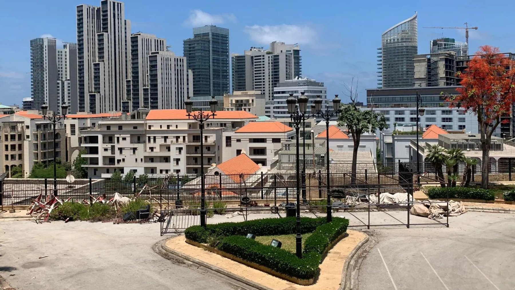 A cityscape featuring modern skyscrapers, residential buildings, and landscaped areas.
