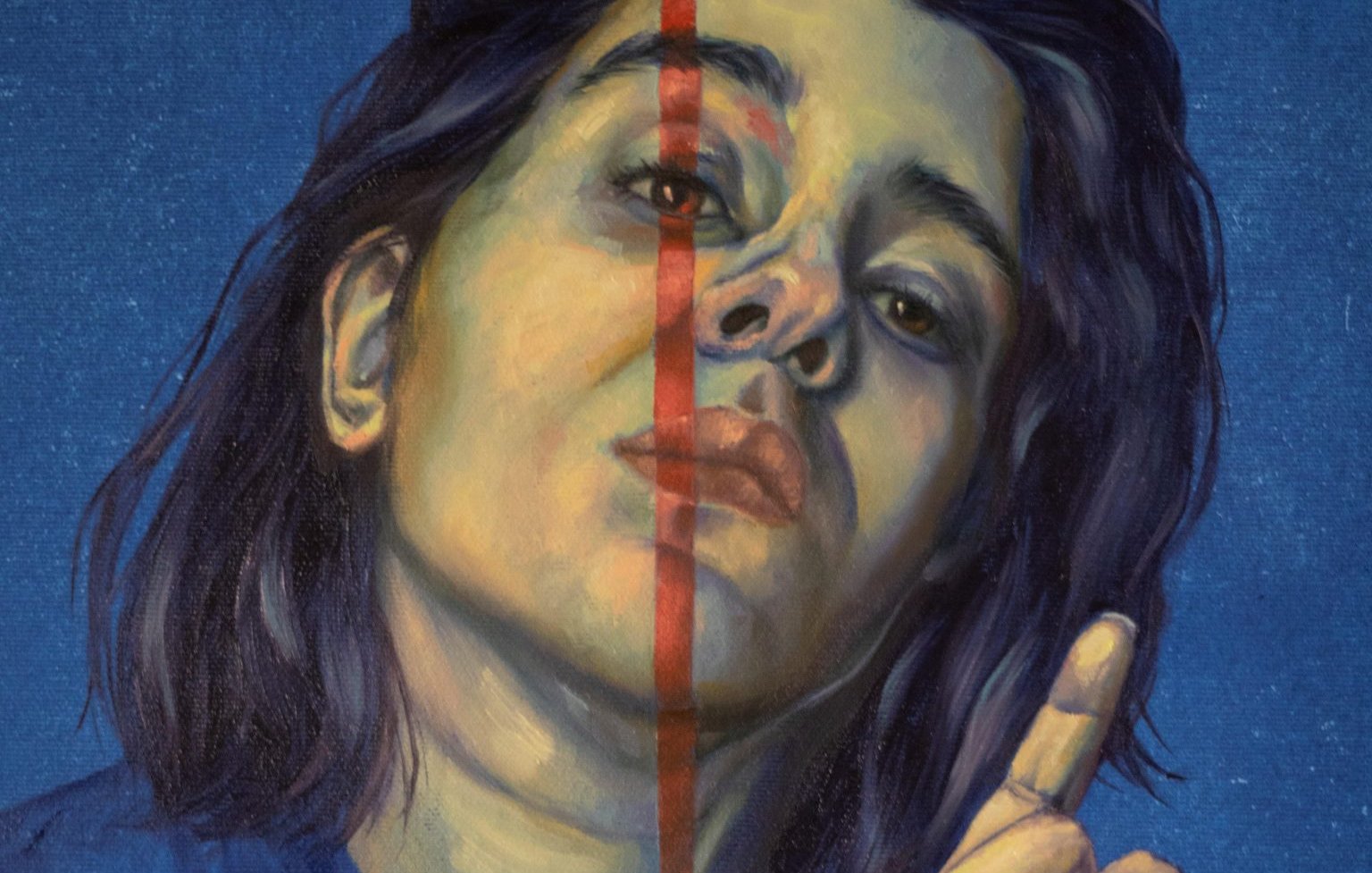 Portrait d'une personne avec un air pensif, moitié visage, fond bleu, donnant un geste de doigt.