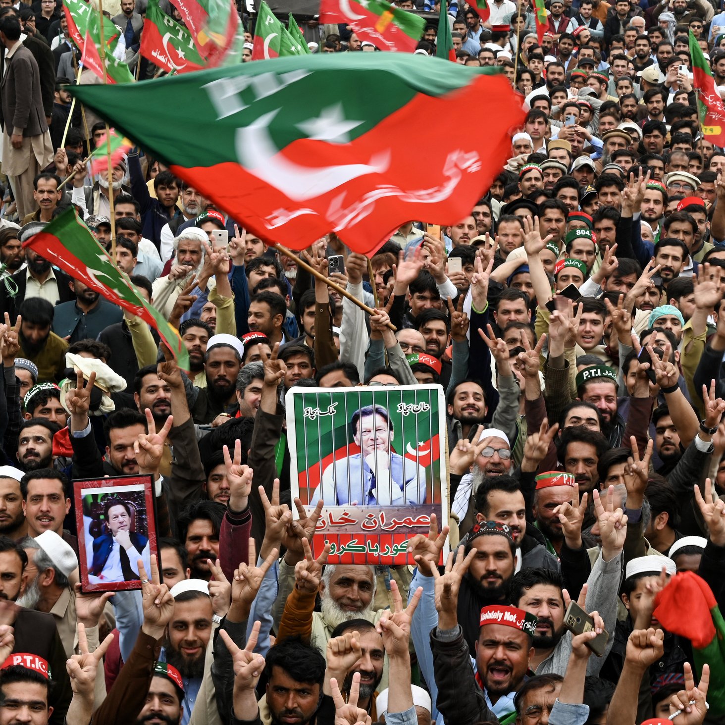 الصورة تظهر حشوداً كبيرة من الأشخاص المحتشدين في فعالية أو تجمع سياسي. يرفع المتظاهرون الأعلام والأصوات، ويعبرون عن حماسهم تجاه موضوع معين. بعضهم يحمل لافتات وصور لشخصيات سياسية، ويبدو عليهم الانتماء لحركة معينة. الأجواء مليئة بالحماس والمشاركة الجماهيرية.