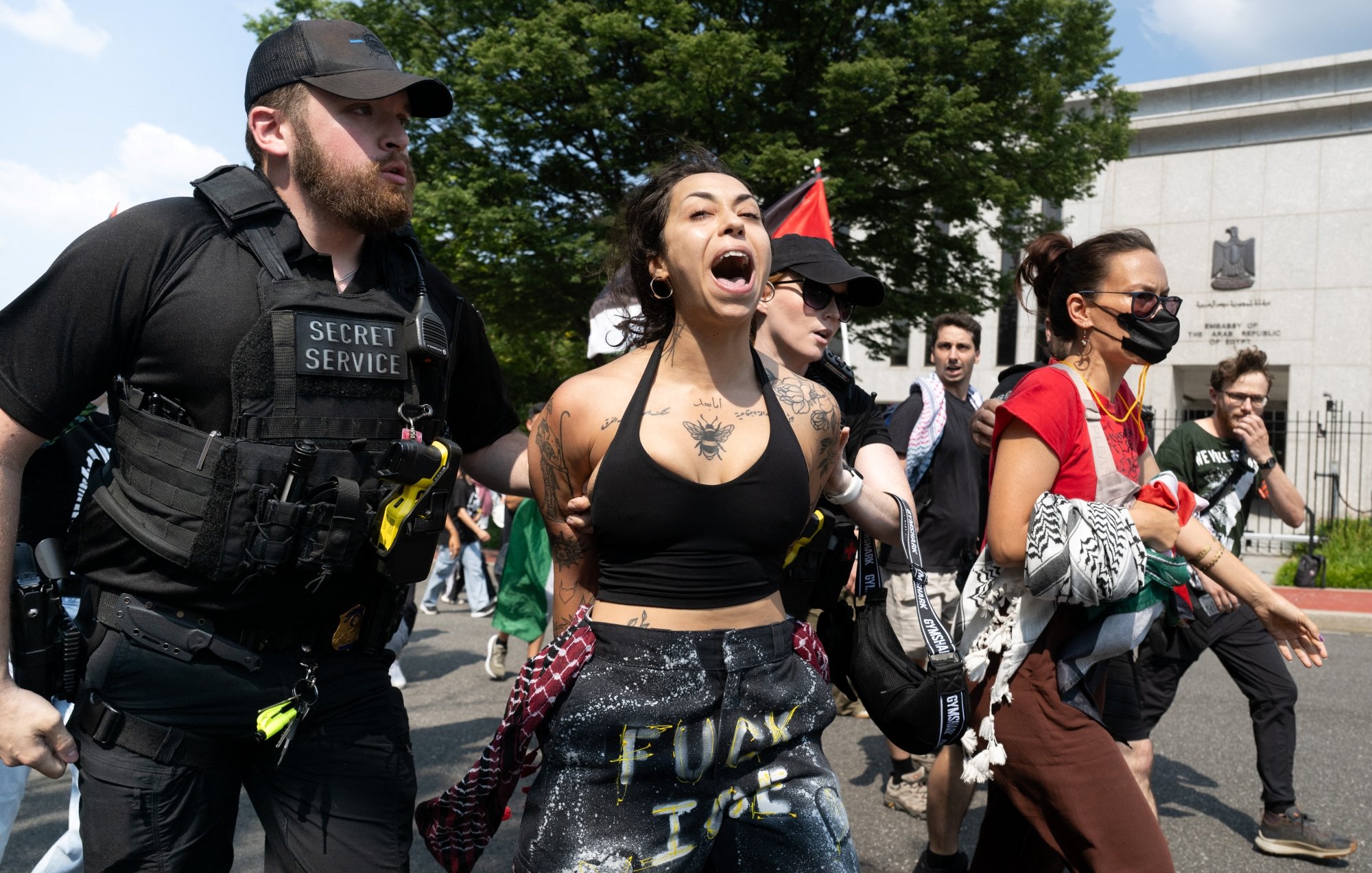 Manifestation intense avec des personnes interpellées par des agents de sécurité.