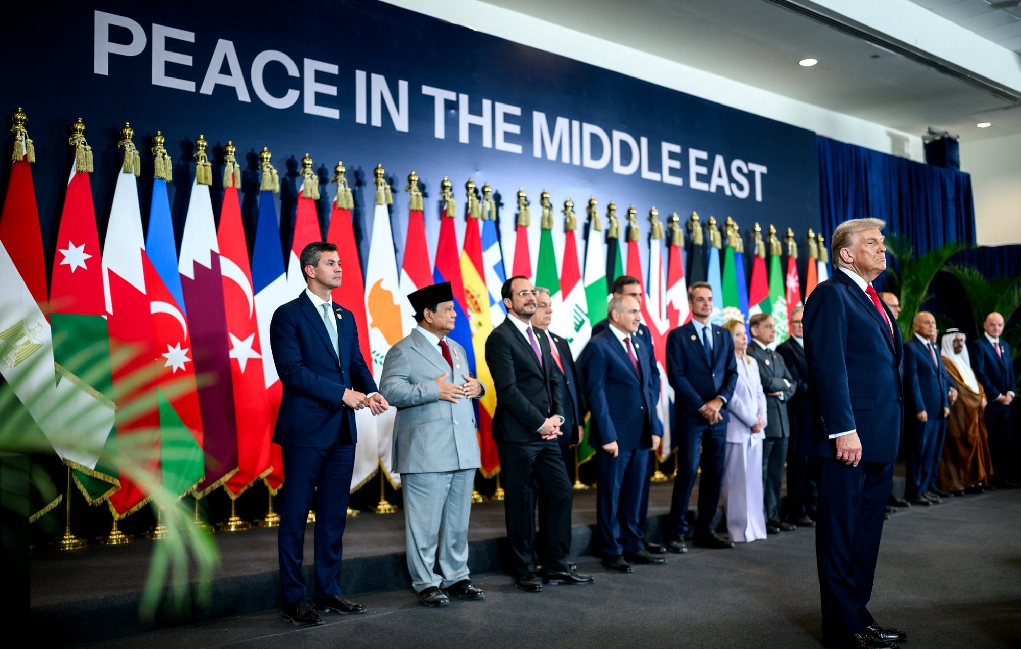 Gruppo di leader con bandiere nazionali sullo sfondo, momento per la pace in Medio Oriente.