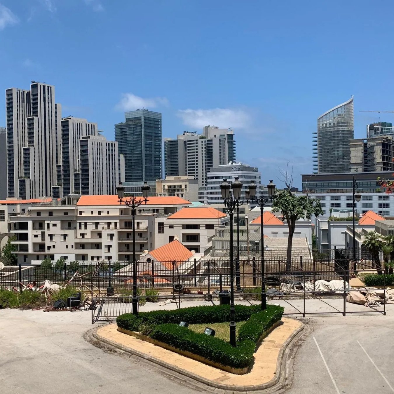 A cityscape featuring modern skyscrapers, residential buildings, and landscaped areas.