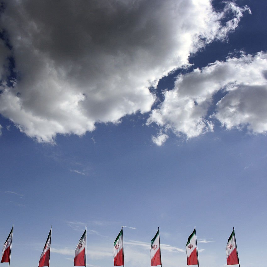 در این تصویر، چند پرچم در حال اهتزاز در برابر آسمانی آبی و ابری دیده می‌شود. پرچم‌ها به رنگ‌های سبز، سفید و قرمز هستند که رنگ‌های ملی ایران را نمایندگی می‌کنند. ابرهای سفید نیز در پس‌زمینه به زیبایی آسمان را تزئین کرده‌اند. این ترکیب تصویری از یک روز آفتابی و شاداب را به نمایش می‌گذارد.