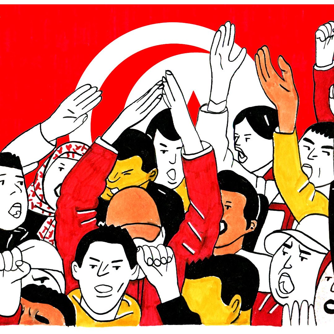 L'image montre un groupe de personnes levant les bras et exprimant des émotions fortes, probablement dans un contexte de manifestation ou de rassemblement. Le fond est orné d'un grand drapeau rouge avec un symbole caractéristique. Les visages sont expressifs, illustrant la passion et l'engagement des participants. On peut observer une diversité dans les vêtements et les expressions, reflétant un sentiment collectif et une volonté d'unité.