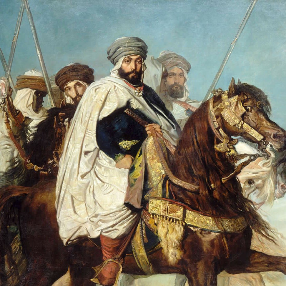 L'image représente un groupe de cavaliers, probablement d'origine orientale, habillés en costumes traditionnels. Au premier plan, un homme est monté sur un cheval majestueux, vêtu d'une tunique ornée et d'un turban. Il semble être le leader ou la figure centrale de ce groupe. Les autres cavaliers en arrière-plan portent également des tenues similaires et tiennent des lances, créant une impression de puissance et de bravoure. Le ciel en arrière-plan est clair, ajoutant une dimension dramatique à la scène. L'ensemble dégage une atmosphère historique et militaire.