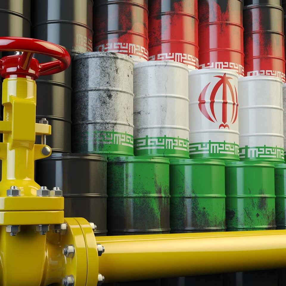 L'image représente un environnement industriel avec des fûts de pétrole disposés en arrière-plan. Les fûts arborent les couleurs du drapeau iranien : rouge, blanc et vert, ainsi que le symbole de l'Iran. À l'avant, il y a une vanne jaune qui semble être une partie d'un système de tuyauterie, probablement reliée à des opérations de transport ou de distribution de pétrole. L'ensemble évoque des thèmes liés à l'industrie pétrolière, en particulier en relation avec l'Iran.