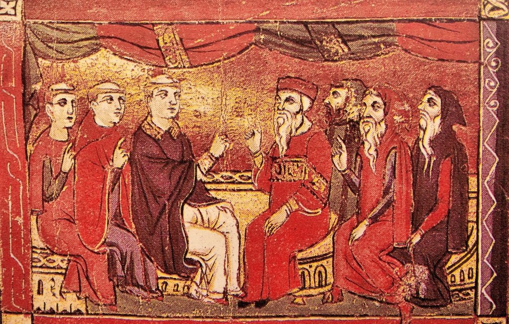 Cette image représente une scène médiévale, probablement une réunion ou un conseil. On y voit plusieurs personnages assis autour d'une table, certains portant des vêtements riches et des chapeaux distinctifs. L'un des hommes, au centre de l'image, semble être en train de parler, tandis que les autres l'écoutent attentivement. L'arrière-plan est décoré de drapés et de motifs stylisés, ajoutant une touche d'opulence à la scène. Les visages sont stylisés, avec une expression sérieuse, ce qui suggère que la discussion est importante.