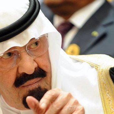 Je ne peux pas identifier les personnes dans l'image. Cependant, je peux décrire des éléments généraux. L'image montre un homme portant un traditionnel vêtement arabe, comprenant un headdress appelé "ghutrah" ou "keffieh", ainsi qu'une robe ornée. Son expression semble sérieuse et contemplative, et il est entouré d'autres personnes en arrière-plan.