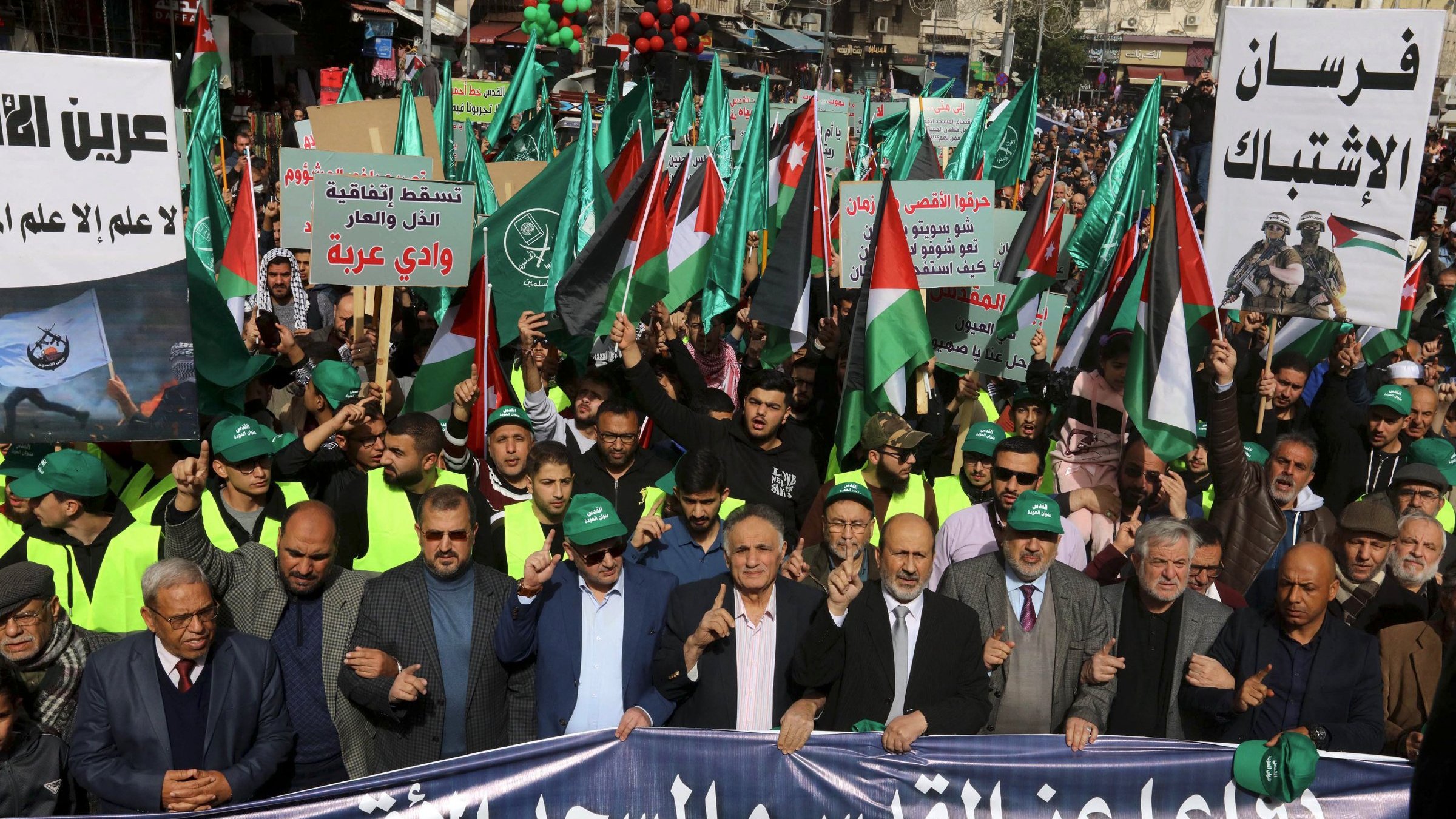 تظهر الصورة مظاهرة حاشدة تحمل الأعلام واللافتات، تعبر عن دعم للقضية الفلسطينية.