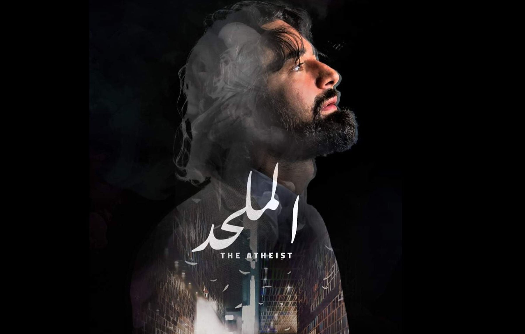 L'image semble représenter une affiche de film intitulée "The Atheist" ou "الملاحد". On y voit un homme avec une expression introspective, le regard tourné vers le haut, entouré de fumée ou de nuages, ce qui crée une ambiance mystérieuse. En arrière-plan, il y a des éléments architecturaux ou urbains. Le titre du film est centré et bien en évidence, avec des informations sur le réalisateur et l'auteur en bas. L'ensemble dégage une atmosphère dramatique et contemplative.