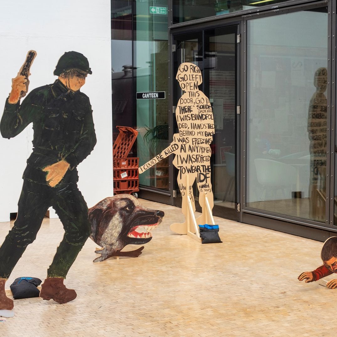 Scène artistique avec un soldat, un chien agressif et un enfant rampant.