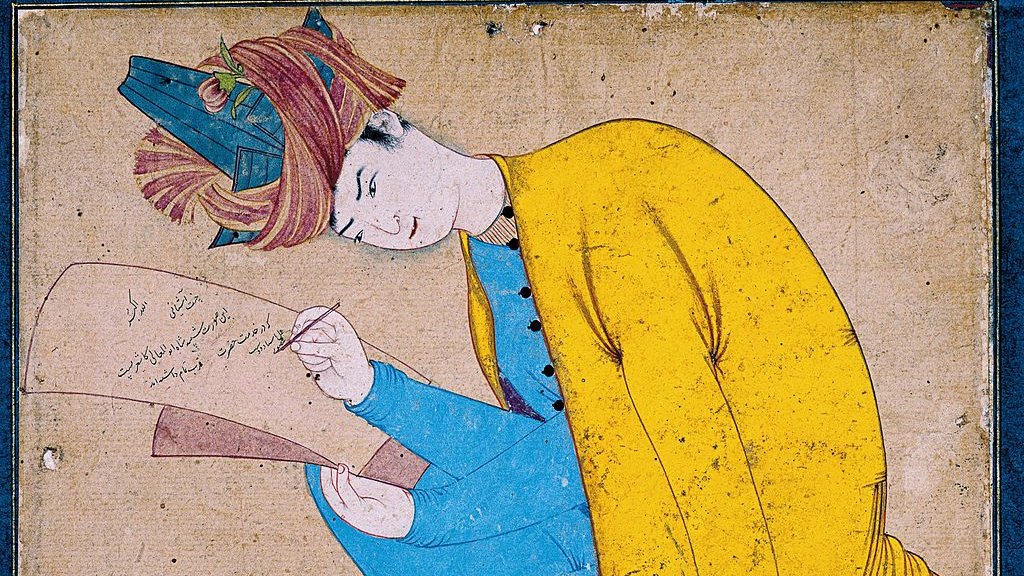 L'image représente un personnage assis, habillé d'un vêtement jaune et d'un pantalon bleu. Il semble concentré, en train d'écrire sur un morceau de papier qu'il tient dans sa main. Sa coiffure est ornée, et il adopte une pose réfléchie. Le fond est sobre, ce qui attire l'attention sur l'acte d'écriture et l'expression du personnage.