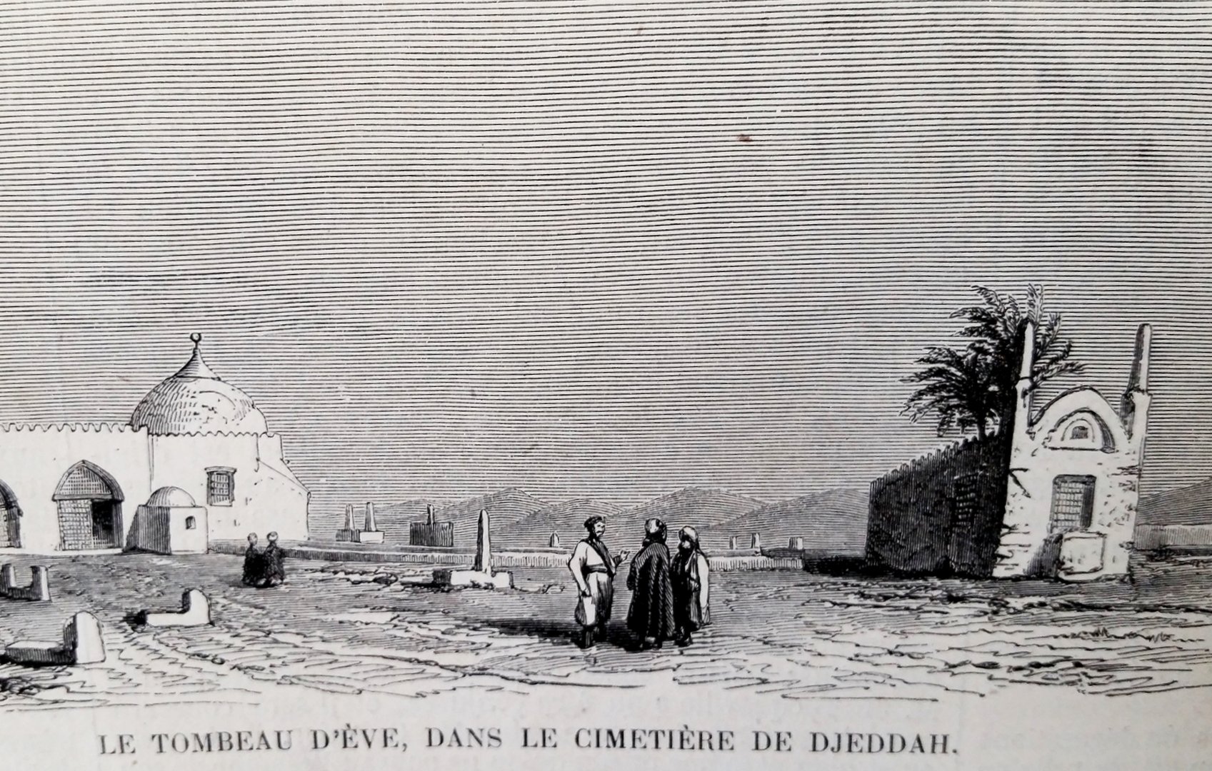 این تصویر نمایی از یک قبرستان را نشان می‌دهد که شامل ساختمانی با گنبد است. در سمت چپ تصویر، یک مقبره با معماری خاص و سنگ‌های مشخص وجود دارد. در وسط تصویر، چند نفر در حال گفتگو یا تماشای اطراف هستند. در پس‌زمینه، تعدادی درخت و سازه‌های دیگری قابل مشاهده هستند. این تصویر به وضوح ابعاد فرهنگی و تاریخی را به تصویر می‌کشد.