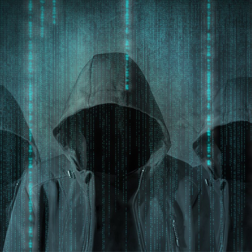 این تصویر نمایی تاریک و دیجیتالی را نشان می‌دهد که در آن سه شخصیت با هودی‌های تیره قرار دارند. چهره‌های آن‌ها نامشخص است و به نظر می‌رسد در پس‌زمینه‌ای پر از خطوط کد و داده‌های دیجیتال قرار دارند. این نمای گویی حس رمزآلودی و فناوری‌های مدرن را منتقل می‌کند، مانند تصاویری که در فیلم‌های سایبرپانک یا مرتبط با هک و دنیای دیجیتال مشاهده می‌شود. رنگ‌های تیره و الگوهای درخشان آبی به شدت توجه را جلب می‌کند.