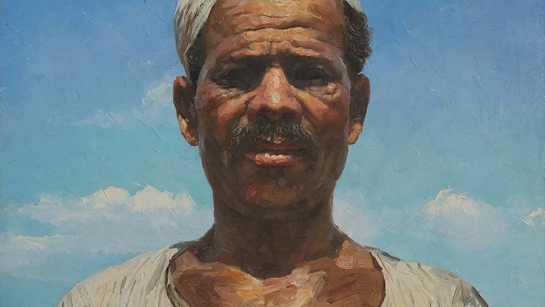 Cette image représente un portrait d'un homme d'une certaine culture, avec un air sérieux et direct. Il a une moustache et porte un turban ou un foulard sur la tête. Son haut est de couleur claire avec des motifs traditionnels. Le fond est constitué d'un ciel bleu clair, parsemé de quelques nuages, ce qui crée un contraste avec son visage. L'éclairage met en valeur les détails de son expression et la texture de sa peau. L'ensemble dégage une impression de force et de caractère.