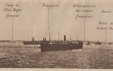 L'image semble représenter une vue panoramique d'un port ou d'une zone maritime, probablement durant une période historique. On y voit plusieurs navires avec des annotations indiquant différentes localisations ou points d'intérêt, tels que : - Transport - Presqu'île de Gallipoli - Éclaireur britannique - Camp de l'Escaut, Major français - Transports - Débarquement des tropas - Pointe de Seddul Bahir - Côte d'Asie - Transport français - Garage Ces indications suggèrent un contexte militaire, possiblement lié à des opérations navales durant la Première Guerre mondiale. Les navires sont rangés en file dans l'eau, illustrant une activité maritime intense.