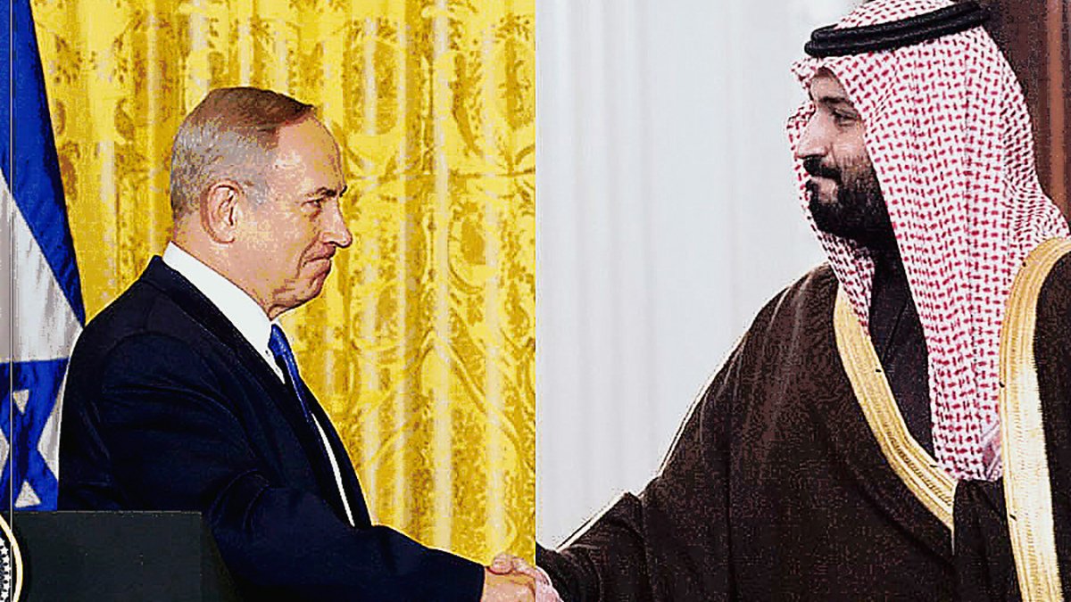 The image depicts two men shaking hands, symbolizing a diplomatic or cooperative gesture. On one side, a man is dressed in a dark suit, and on the other side, another man is wearing traditional attire, including a headdress. The background features a decorative curtain and possibly elements indicative of a formal setting, suggesting the significance of their meeting, likely related to political or international relations.