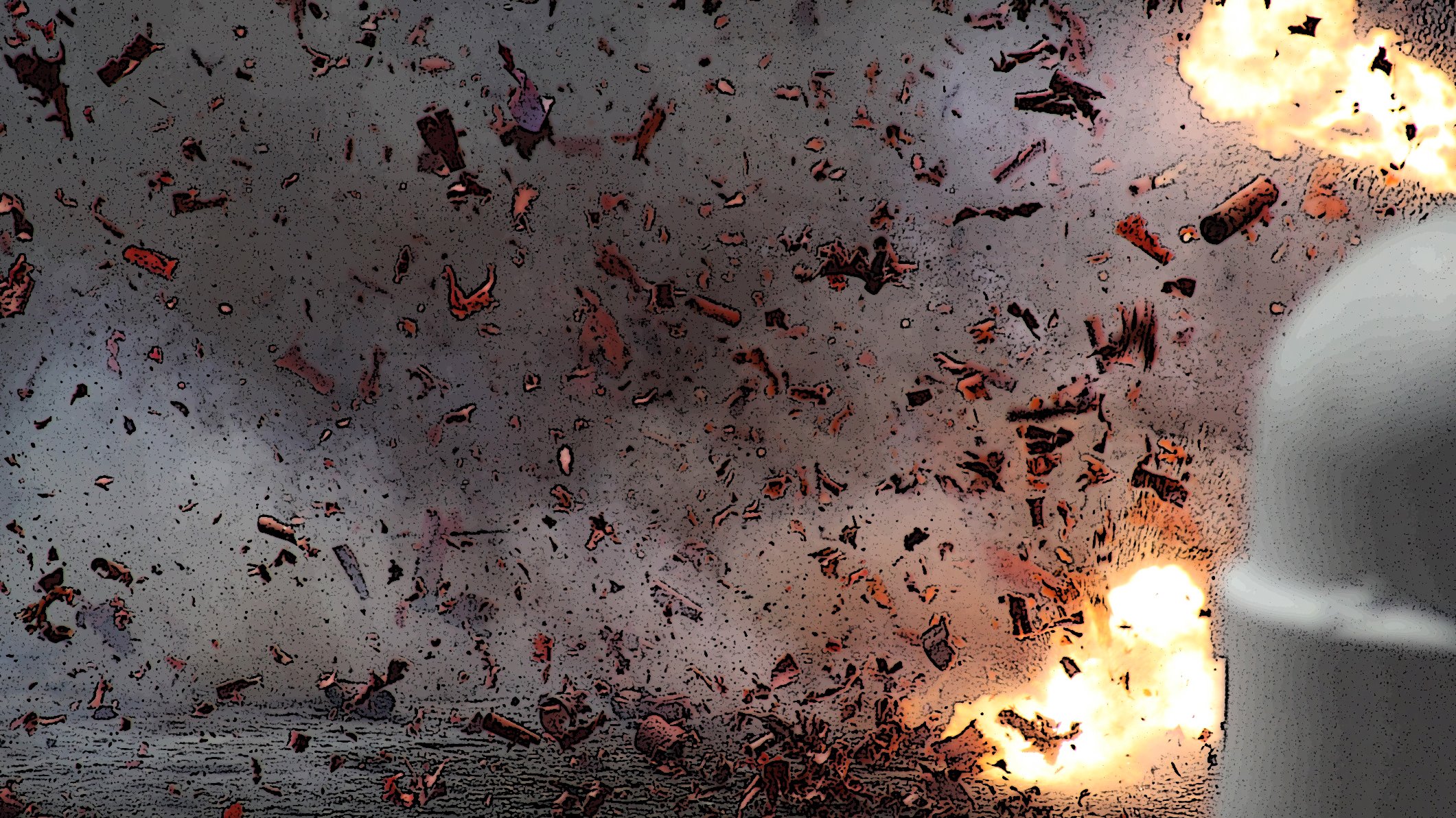 L'immagine mostra un'esplosione con schegge volanti e fumi che si diffondono nell'aria. Ci sono lampi di luce brillante provenienti dall'esplosione, creando un effetto drammatico. Sullo sfondo si intravedono detriti e una scena che evoca un momento di grande intensità. L'atmosfera appare caotica e carica di energia.