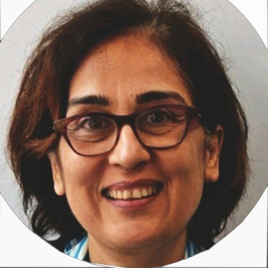 Femme souriante avec des lunettes, cheveux bruns et frisés, fond neutre.