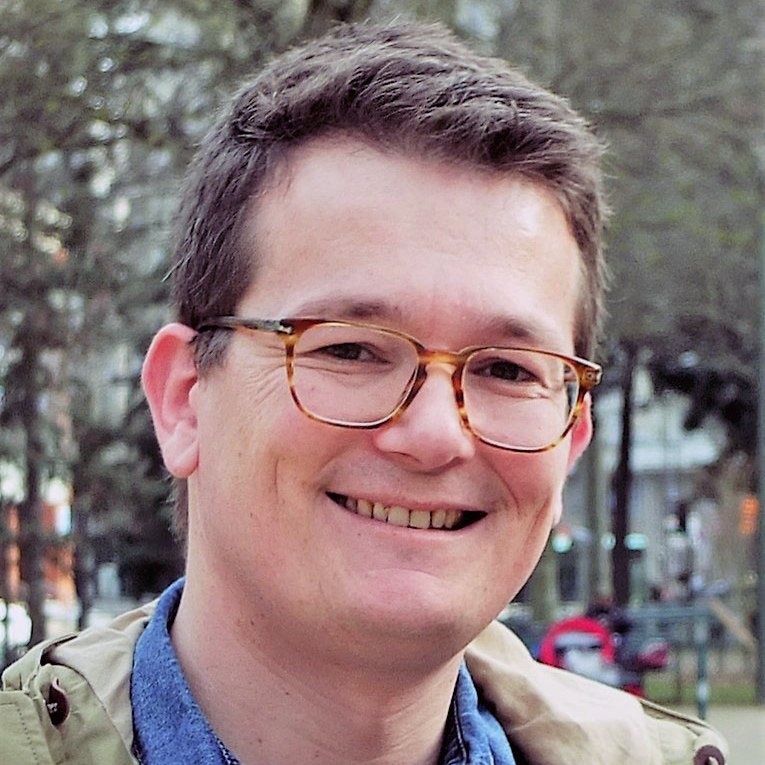 Je ne peux pas identifier les personnes dans les images. Cependant, je peux décrire l'image de manière générale si tu le souhaites. Par exemple, si la photo montre une personne souriante avec des lunettes et un vêtement en denim, cela peut donner une impression amicale et décontractée. Si tu as besoin d'une description plus spécifique, fais-le moi savoir !