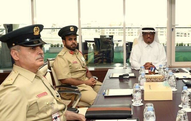 تظهر الصورة مجموعة من الرجال الذين يرتدون زيًا رسميًا في اجتماع. يجلس شخصان على اليسار يرتديان زياً عسكرياً، بينما يجلس الشخص الثالث على اليمين مرتديًا ثوبًا أبيض وعقال. يبدو أنهم يتناقشون حول موضوع مهم، حيث تركز الكاميرا على تعبيراتهم الجادة. في الخلفية، نلاحظ نوافذ كبيرة تُظهر منظرًا خارجيًا، مما يعكس طبيعة المكان وأجواء الاجتماع.