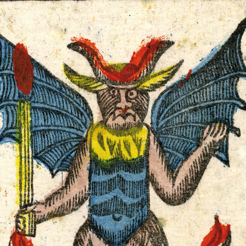 L'image représente une créature fantastique, possédant des ailes de chauve-souris et des traits anthropomorphes. Elle a un visage particulier, avec des yeux marquants et une expression qui semble imposante. Son corps est recouvert d'un pelage brun, et elle porte une sorte de costume coloré avec des éléments jaunes et bleus. Dans l'une de ses mains, elle tient un bâton. L'ensemble évoque une figure démoniaque ou mythologique, avec un style artistique détaillé et coloré.