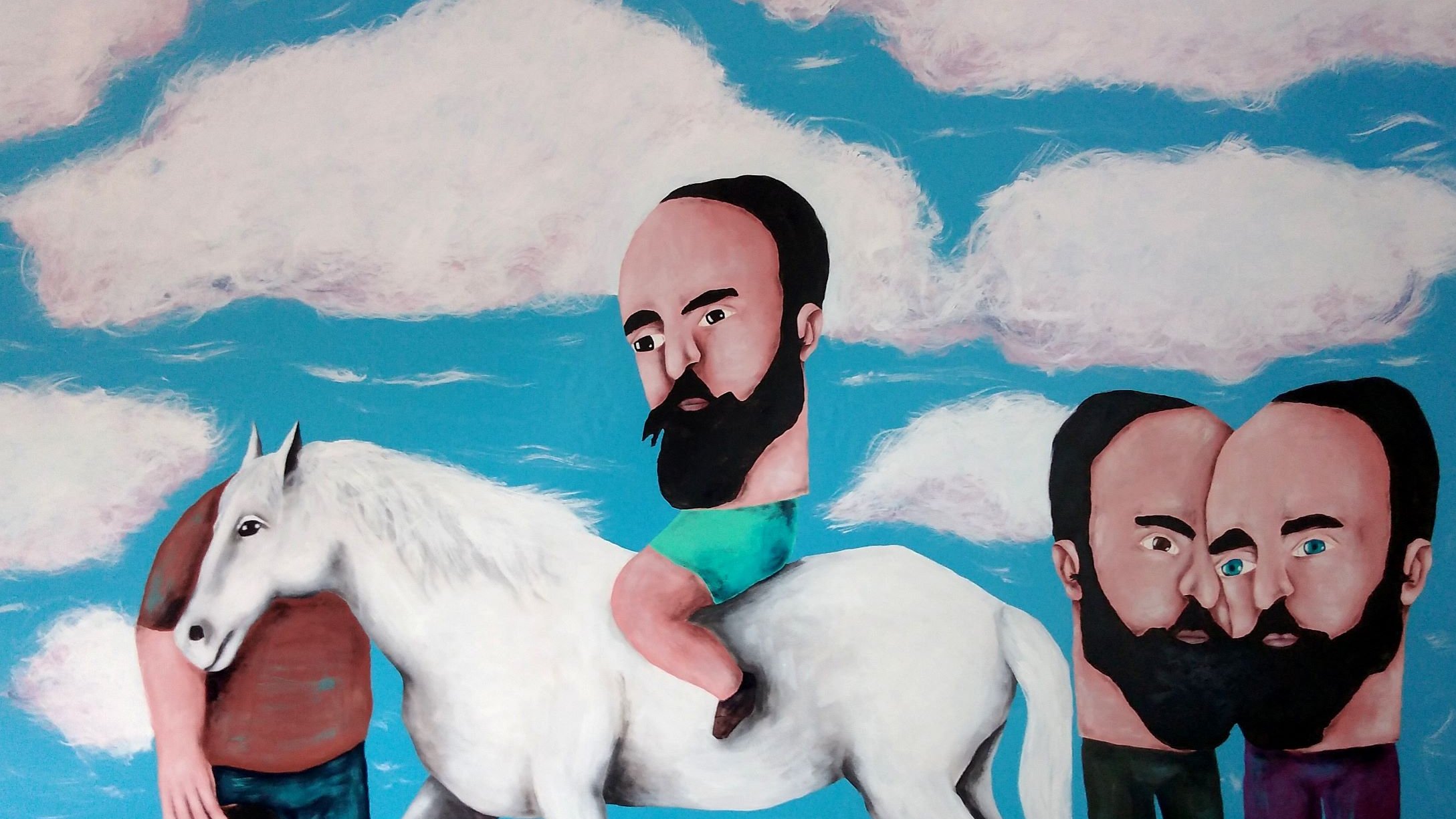 L'image représente une scène surréaliste avec un arrière-plan bleu et des nuages. On y voit un homme chevauchant un cheval blanc, tandis qu'un autre homme est à côté avec une posture étrange. Les personnages ont des têtes disproportionnées et des barbes. L'un des hommes semble avoir sa tête en bas, ajoutant une dimension absurde à l'œuvre. L'ensemble évoque une atmosphère onirique et ludique.