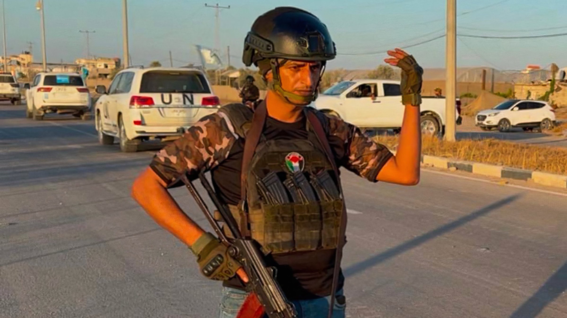 Un uomo in uniforme militare, con un fucile e un elmetto, si erge su una strada.