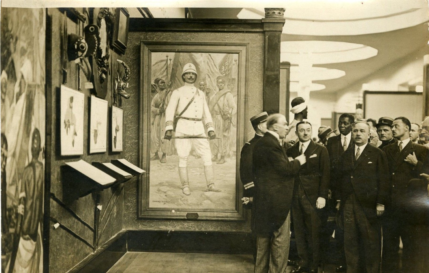 Des hommes en costume admirent un tableau d'un soldat dans un musée.