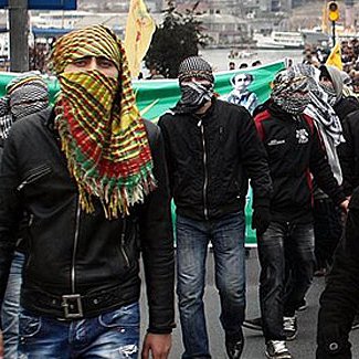 تظهر الصورة مجموعة من الأشخاص في مظاهرة أو تجمع حاشد. يرتدي المتظاهرون أغطية رأس أو وشاحًا، مما يُعطي انطباعًا عن الاحتجاج أو التعبير عن موقف سياسي. يمكن رؤية لافتات وخلفية تعكس حيوية الحدث. يبدو أن المشاركين يعبرون عن آرائهم بشكل قوي، وقد تكون الصورة مرتبطة بقضايا اجتماعية أو سياسية معينة.