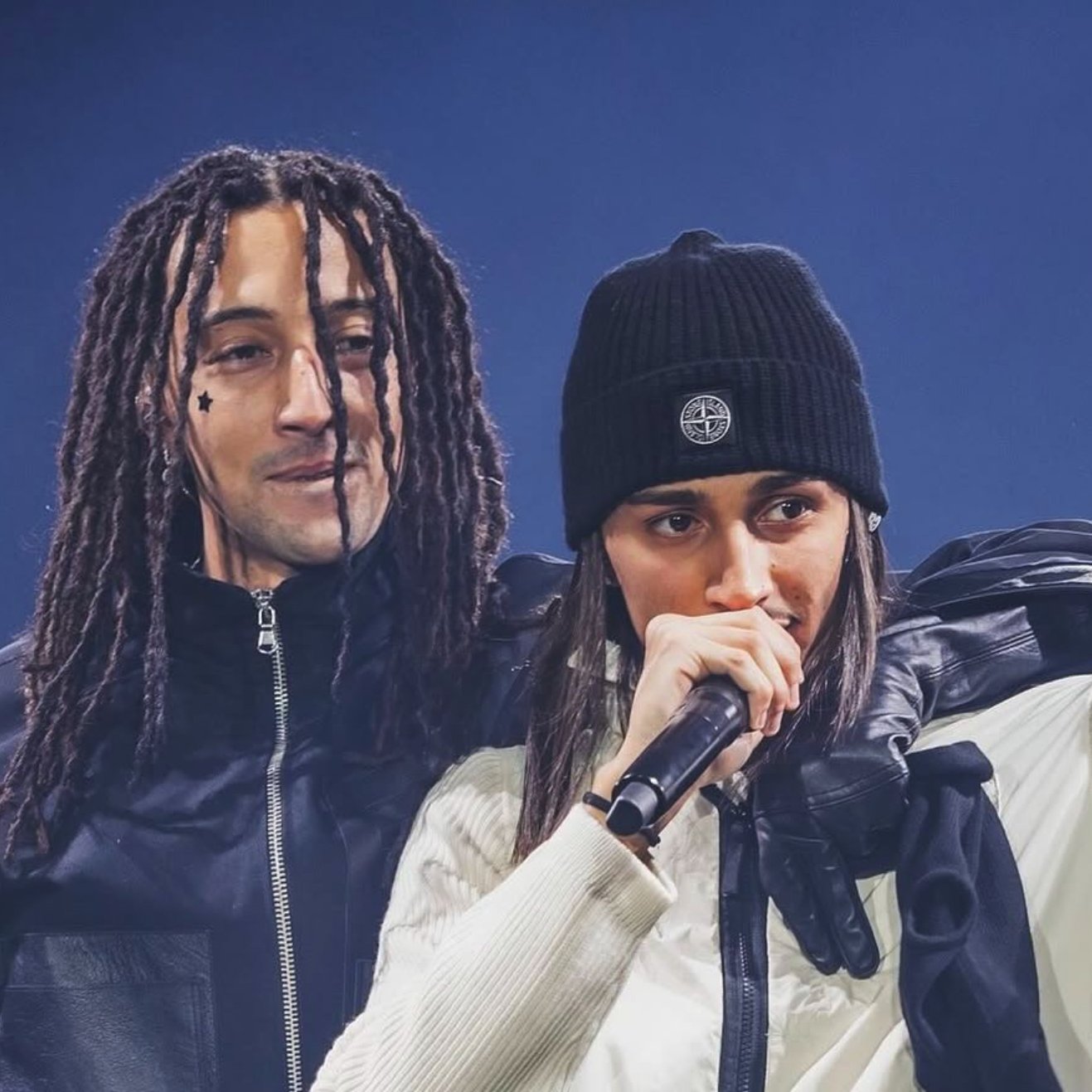 Deux artistes sur scène, l'un avec des dreadlocks, l'autre avec un bonnet, micro à la main.