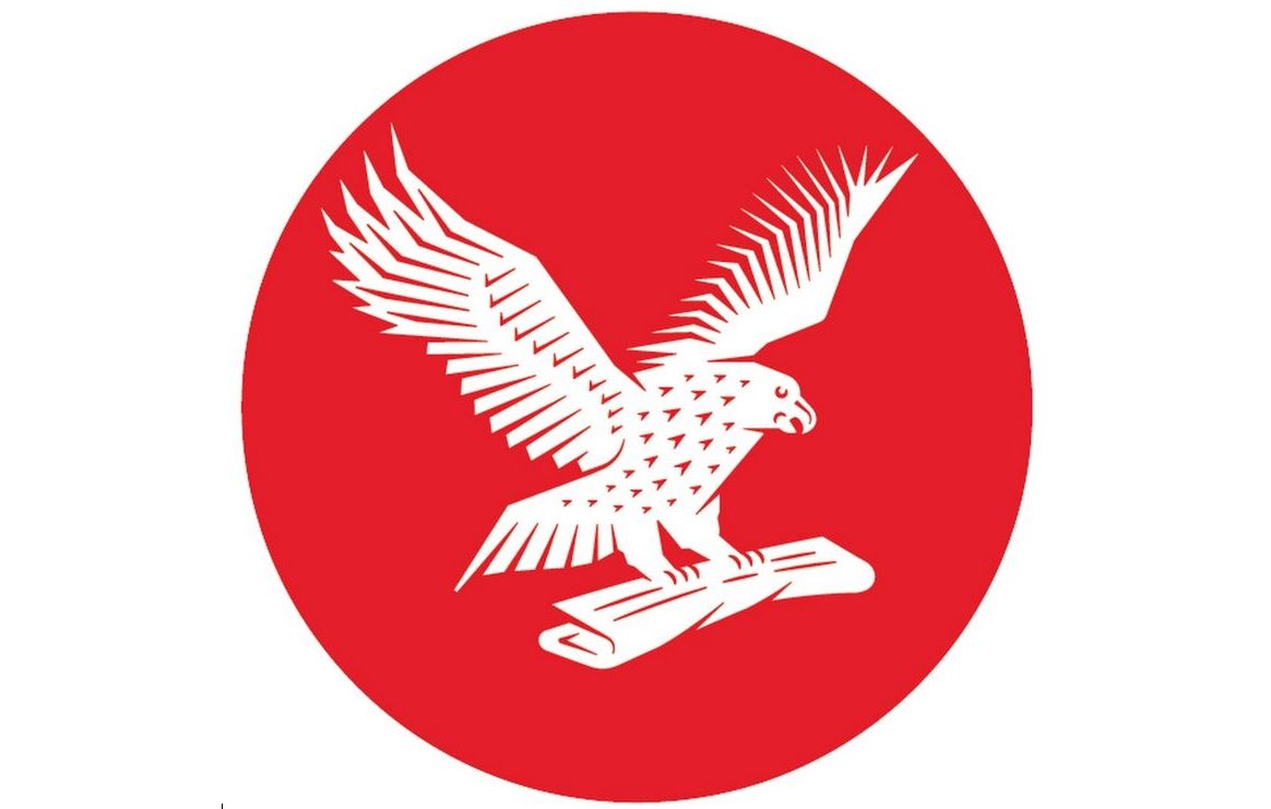 The image features a stylized eagle with outstretched wings, depicted in white, set against a bright red circular background. The eagle is perched on a scroll or rolled-up document. The overall design is bold and simplistic, emphasizing the eagle's dynamic posture.