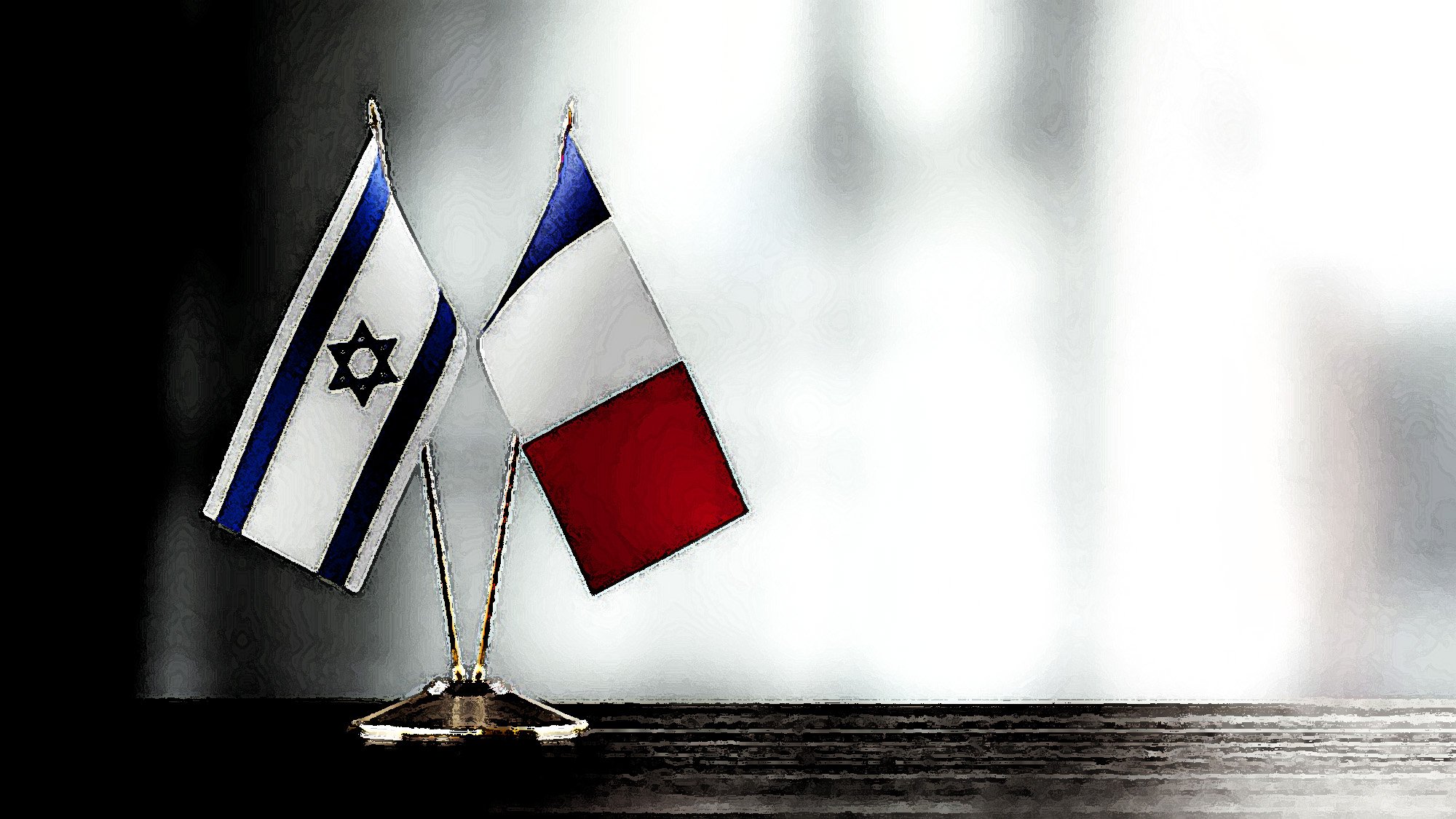 L'image montre deux drapeaux miniatures sur un support : l'un est le drapeau d'Israël, avec son étoile de David en bleu sur fond blanc, et l'autre est le drapeau de la France, avec ses bandes verticales bleu, blanc et rouge. Les drapeaux sont disposés côte à côte, créant une ambiance de collaboration ou de représentation entre les deux nations. Le fond est flou et lumineux, ce qui met en avant les drapeaux.