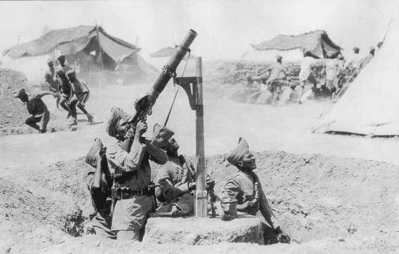 در این تصویر، تعدادی سرباز در حال کار با یک خمپاره‌انداز دیده می‌شوند. آن‌ها در یک سنگر قرار داشته و یکی از آن‌ها در حال هدف‌گیری خمپاره است. در پس‌زمینه، گروهی از سربازان دیگر مشغول فعالیت هستند و چندین چادر نظامی در دوردست مشاهده می‌شود. فضای تصویر نشان‌دهنده یک صحنه نظامی و فعالیت‌های جنگی است.