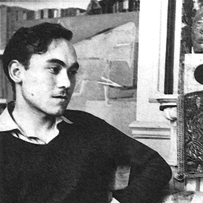 L'image présente un jeune homme assis, vêtu d'un pull noir et d'une chemise claire. Il a les cheveux foncés et porte une expression pensive, regardant légèrement à gauche. Le décor en arrière-plan suggère un intérieur avec des éléments architecturaux, bien que les détails ne soient pas très clairs. L'atmosphère de la photo semble rétro, avec un contraste marqué entre les ombres et la lumière.